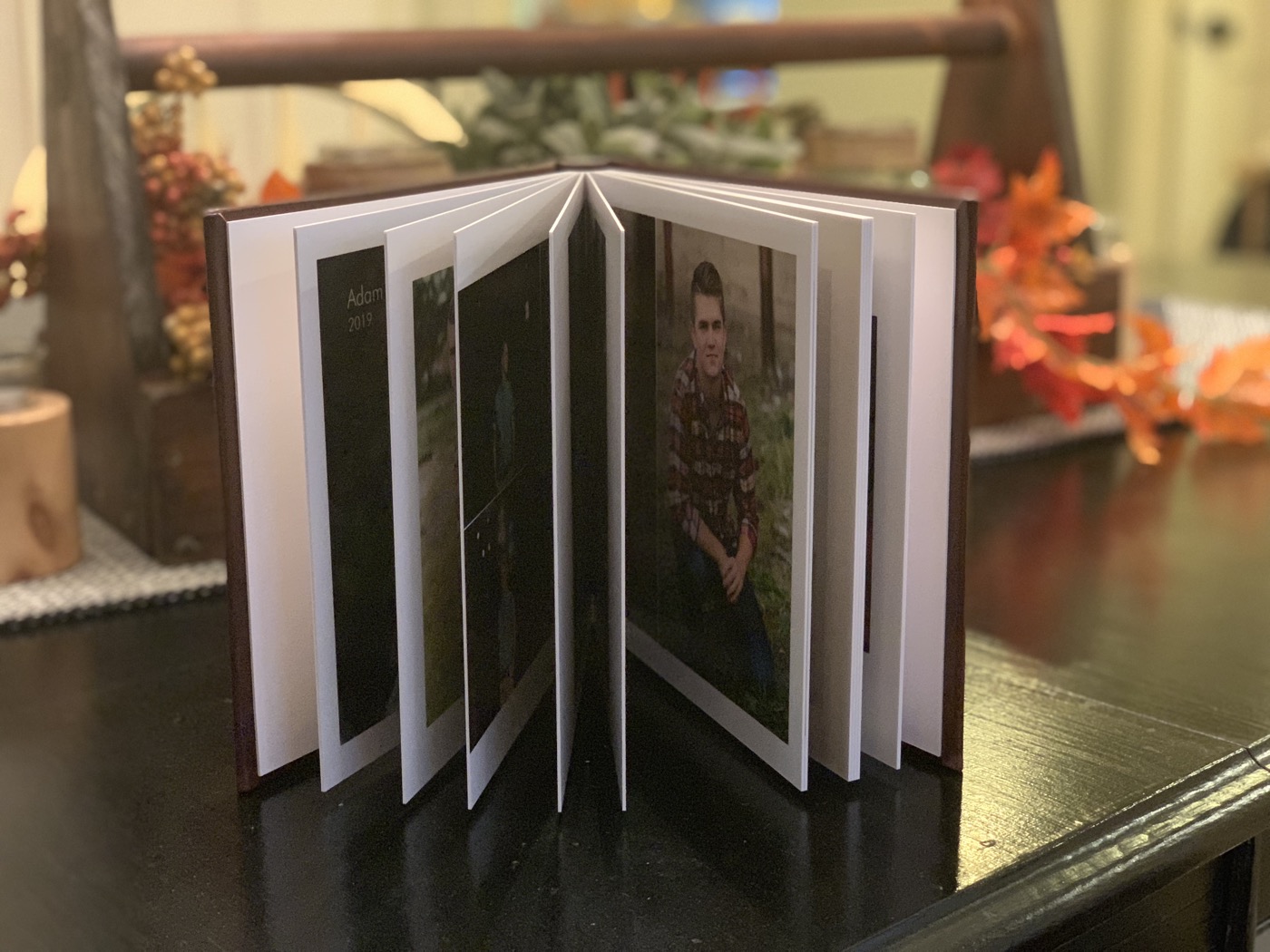 Small signature album fanned open showing portrait spreads