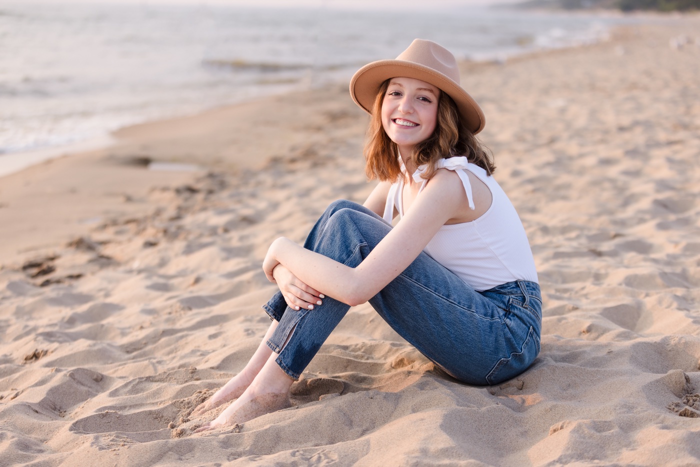 Senior wearing a hat at Lake Michigan in Holland during a portrait session — Jules K Photography