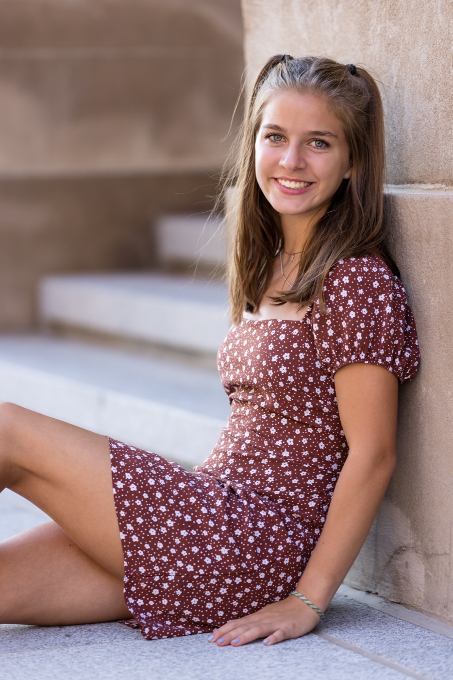 Senior in earth tone outfit against a building in downtown Grand Rapids Michigan — Jules K Photography