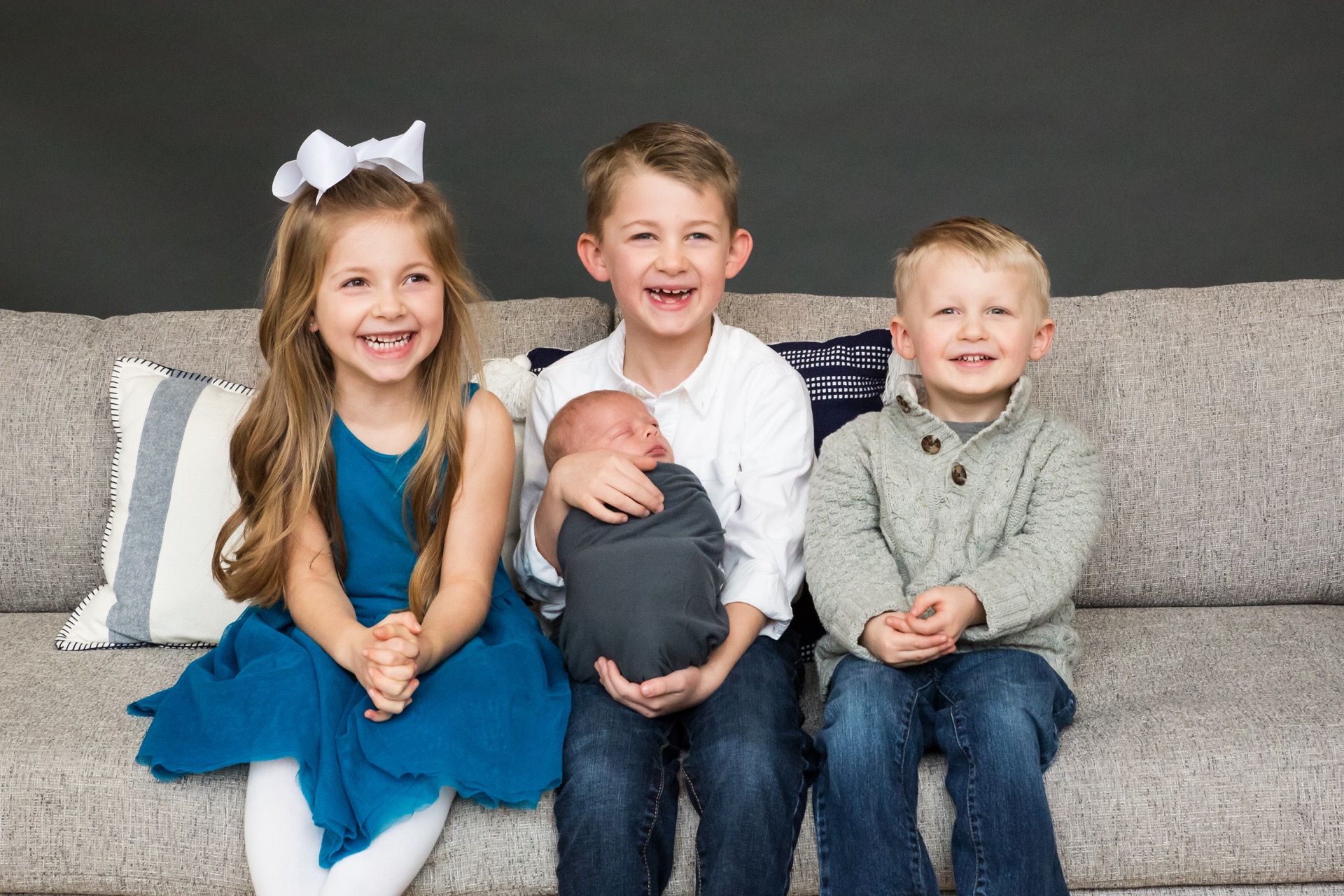 Siblings holding newborn baby portrait Grand Rapids