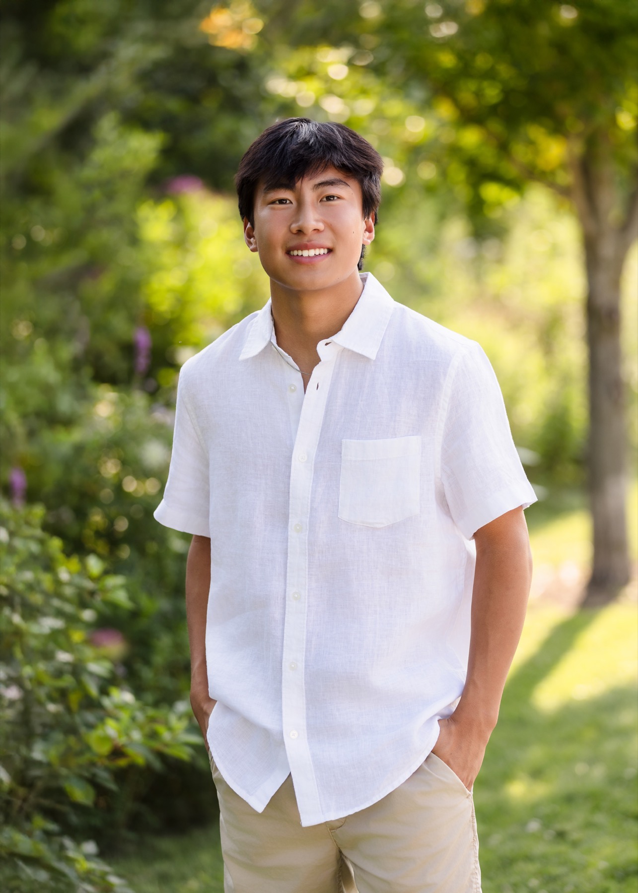 High school senior boy smiling in white linen shirt, portrait session in the Forest Hills Michigan area