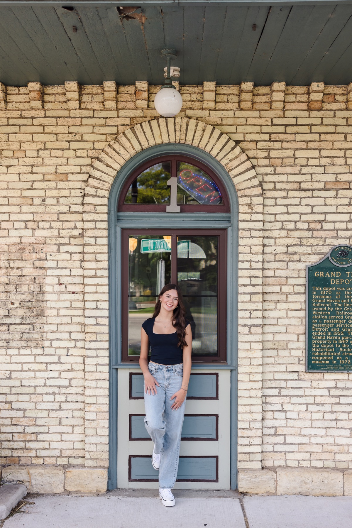 Senior girl at the historic Grand Trunk Depot arched doorway in Grand Haven Michigan