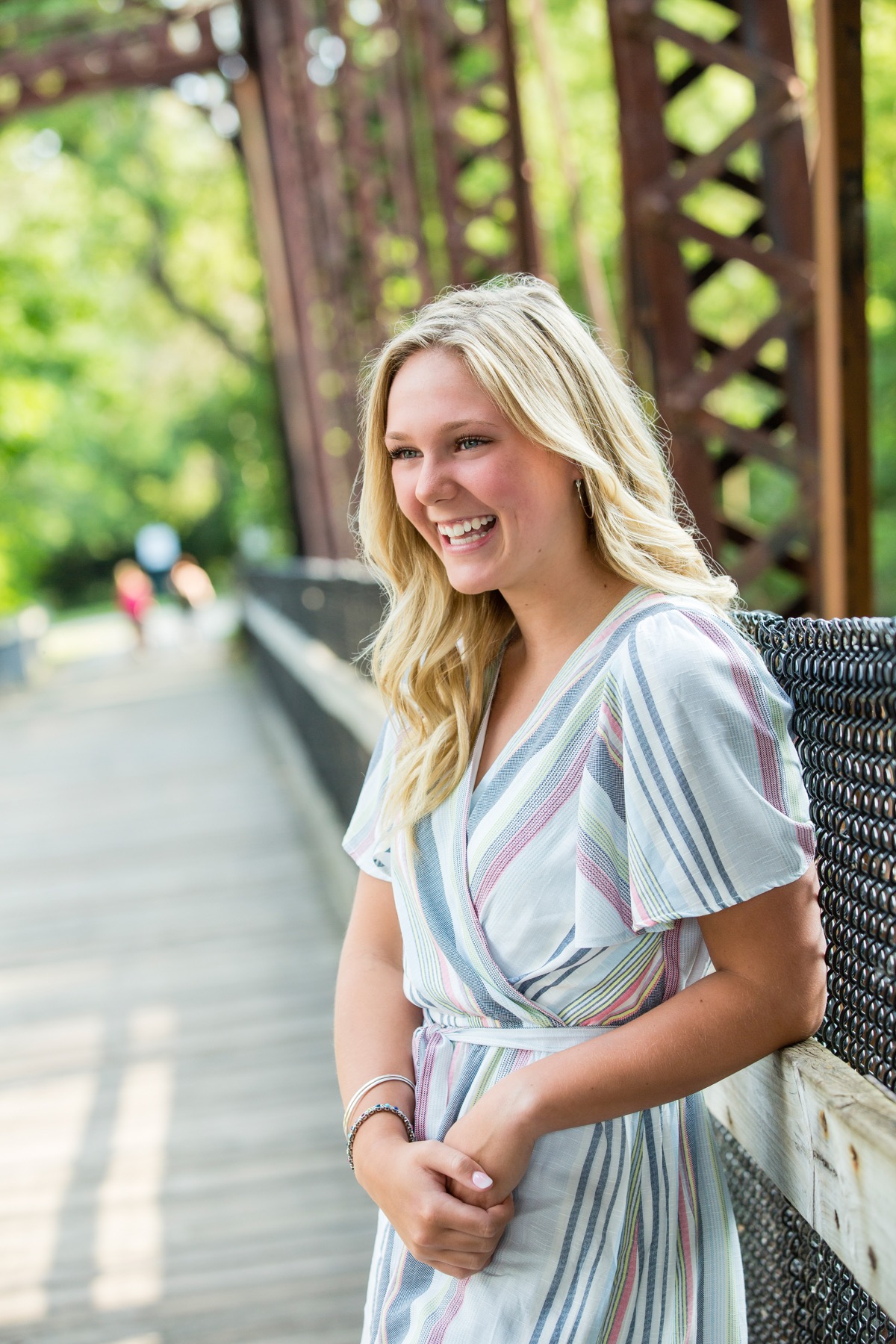 High school senior laughing on the Rockford footbridge during portrait session
