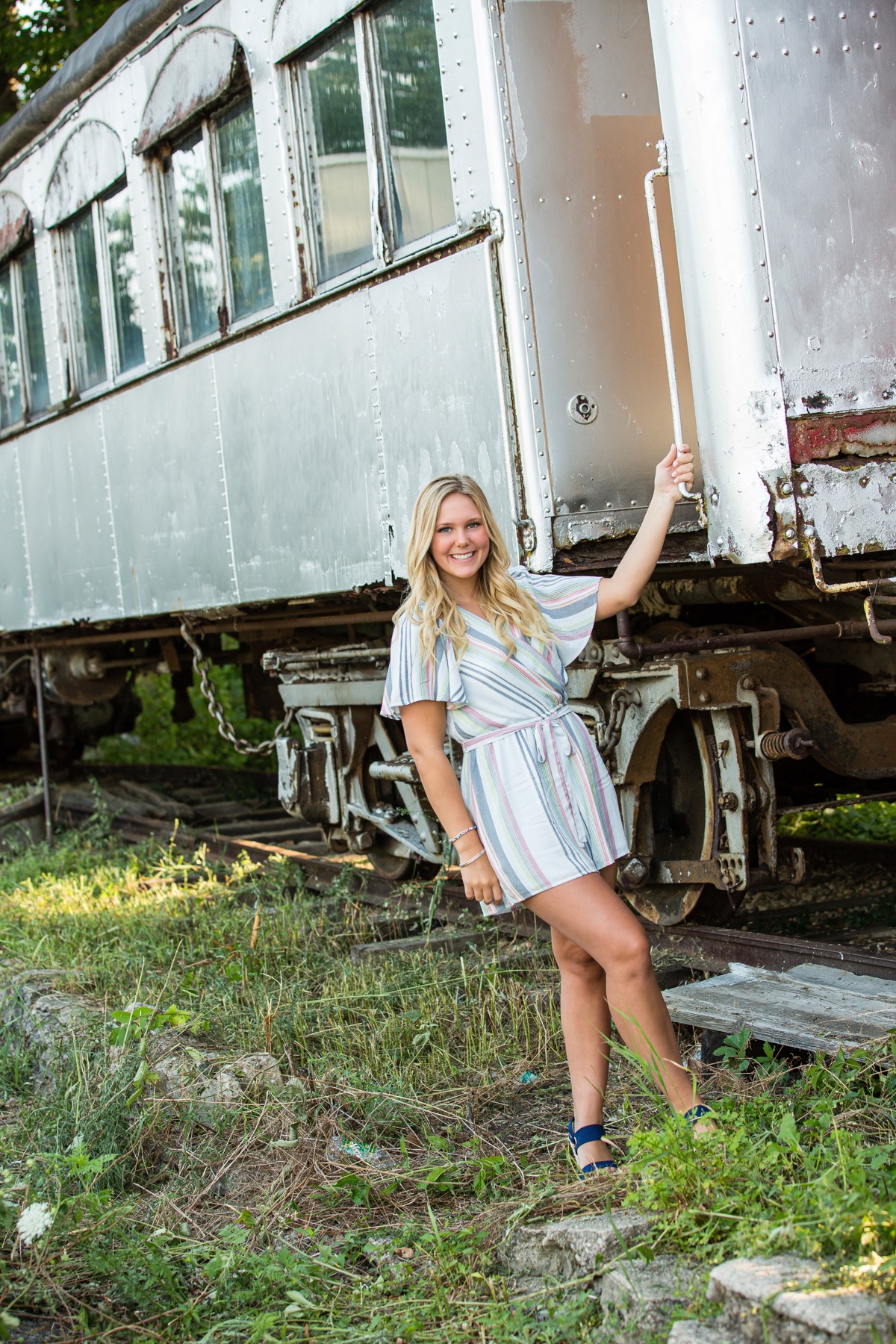 Senior portrait by vintage railcar in downtown Rockford Michigan